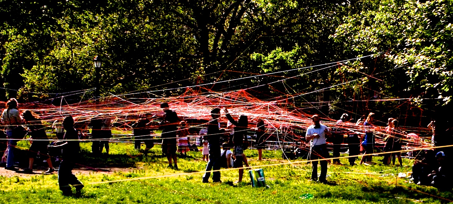 Crowds gather inside a massive red and orange string web at McCarren Park, Brooklyn