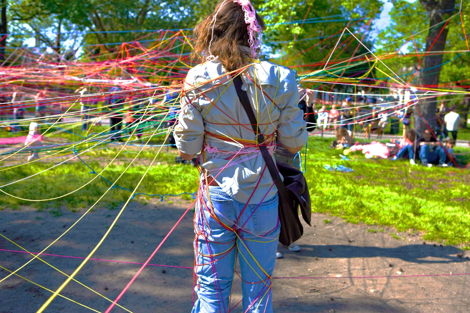 Person wrapped from head to toe in rainbow string