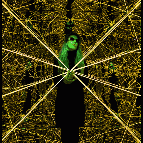 Animated loop of Elastic Light — glowing rainbow strands radiating around the artist